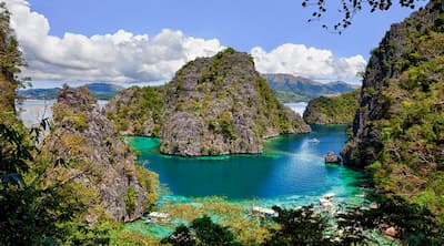 An outrigger anchored in clear El Nido shallows