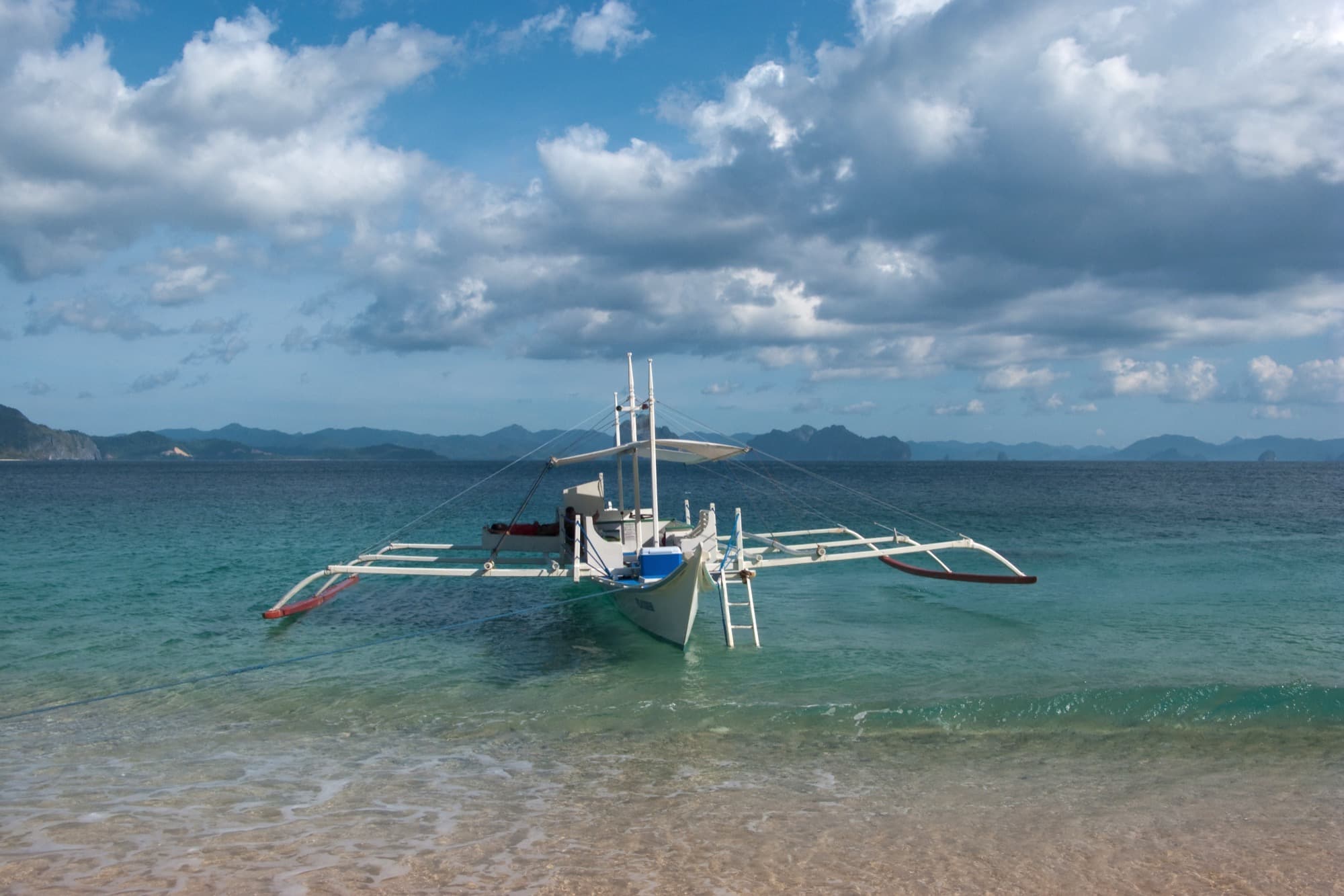 A private banca anchored off a white sandbar
