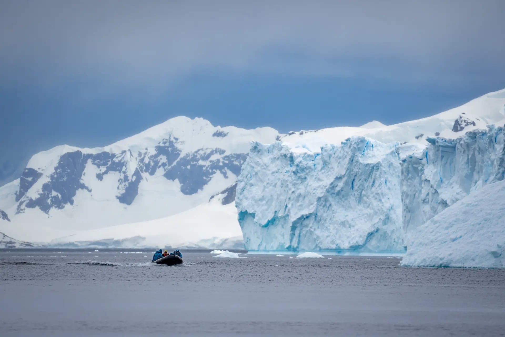 A zodiac dwarfed by the glacier front at Danco Island