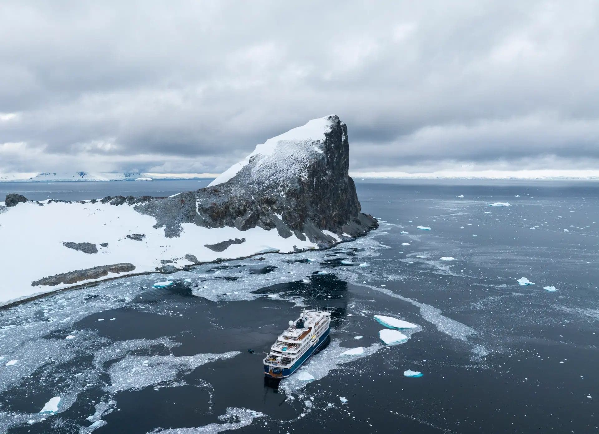 The expedition ship at anchor beneath the spire of Orne Harbour